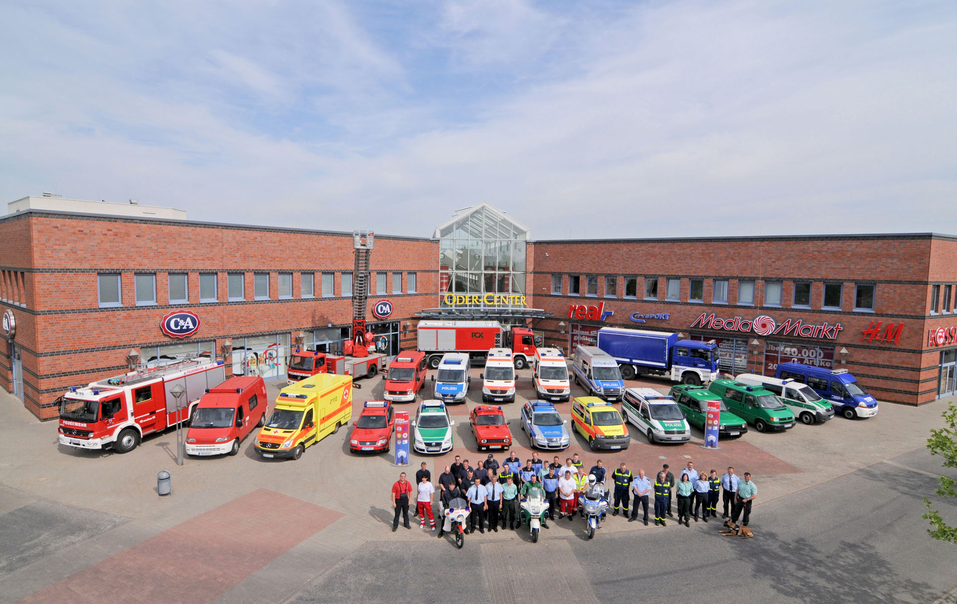 Foto: Teilnehmer mit Fahrzeugen haben vor dem Center Aufstellung genommen.