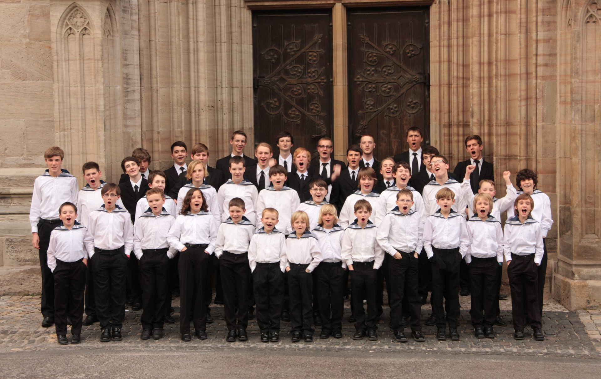 Foto: Knabenchor vor einem Kirchenportal