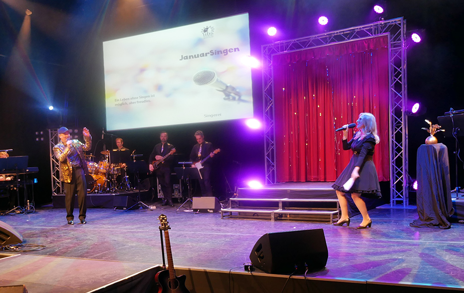 Foto: Sängerin und Sänger mit Band auf der Bühne Foto: Sängerin und Sänger mit Band auf der Bühne