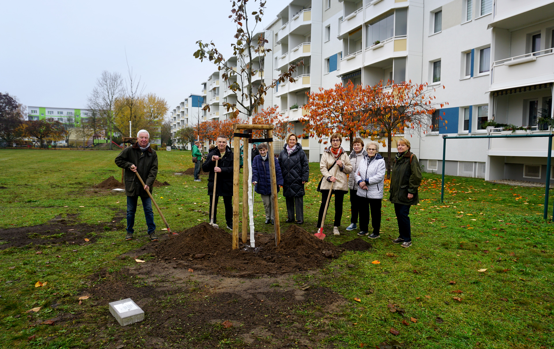 Gruppenfoto mit neu gepflanzten Baum Gruppenfoto mit neu gepflanzten Baum