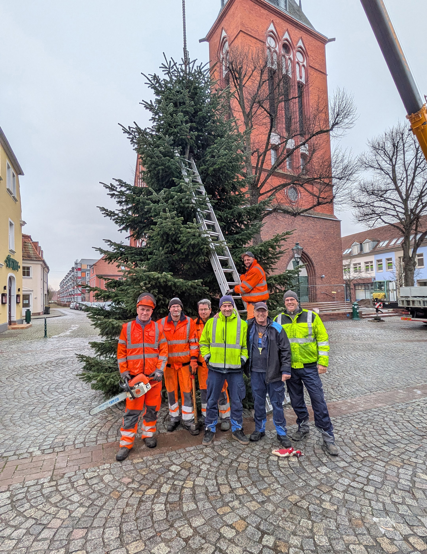 Foto: Gruppenfoto vor der aufgestellten Tanne