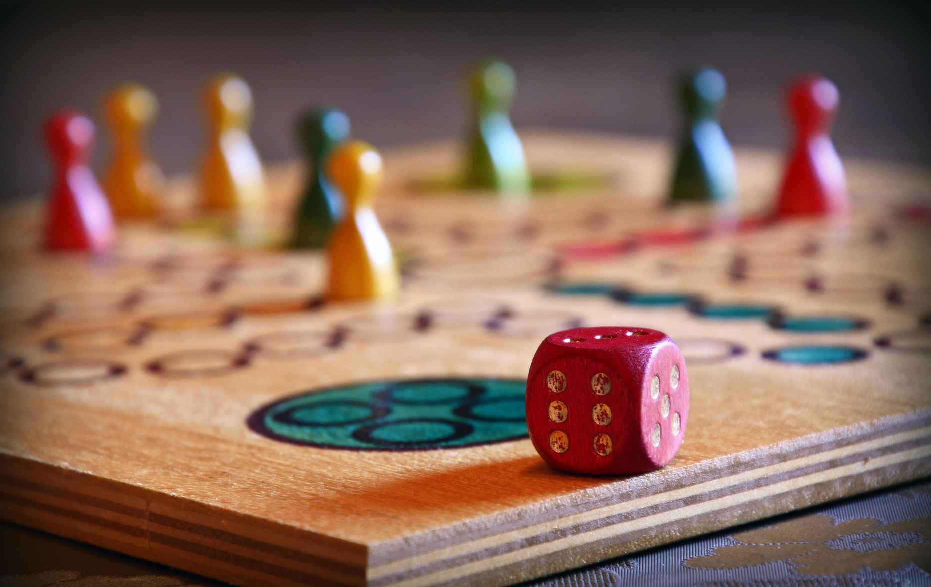 Foto: Spielfiguren und Würfel auf einem Spielfeld