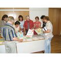 Foto: Gruppe steht um einen Tisch herum.