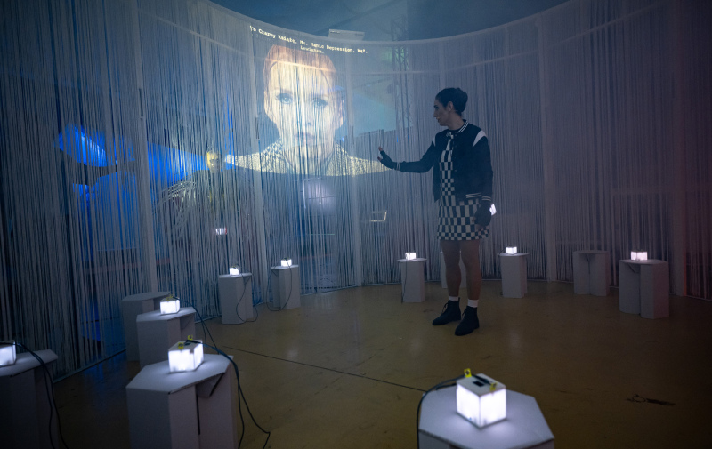 Foto: Bildschirm an der Bühnenrückwand und leuchtende Cubes für die Interaktion