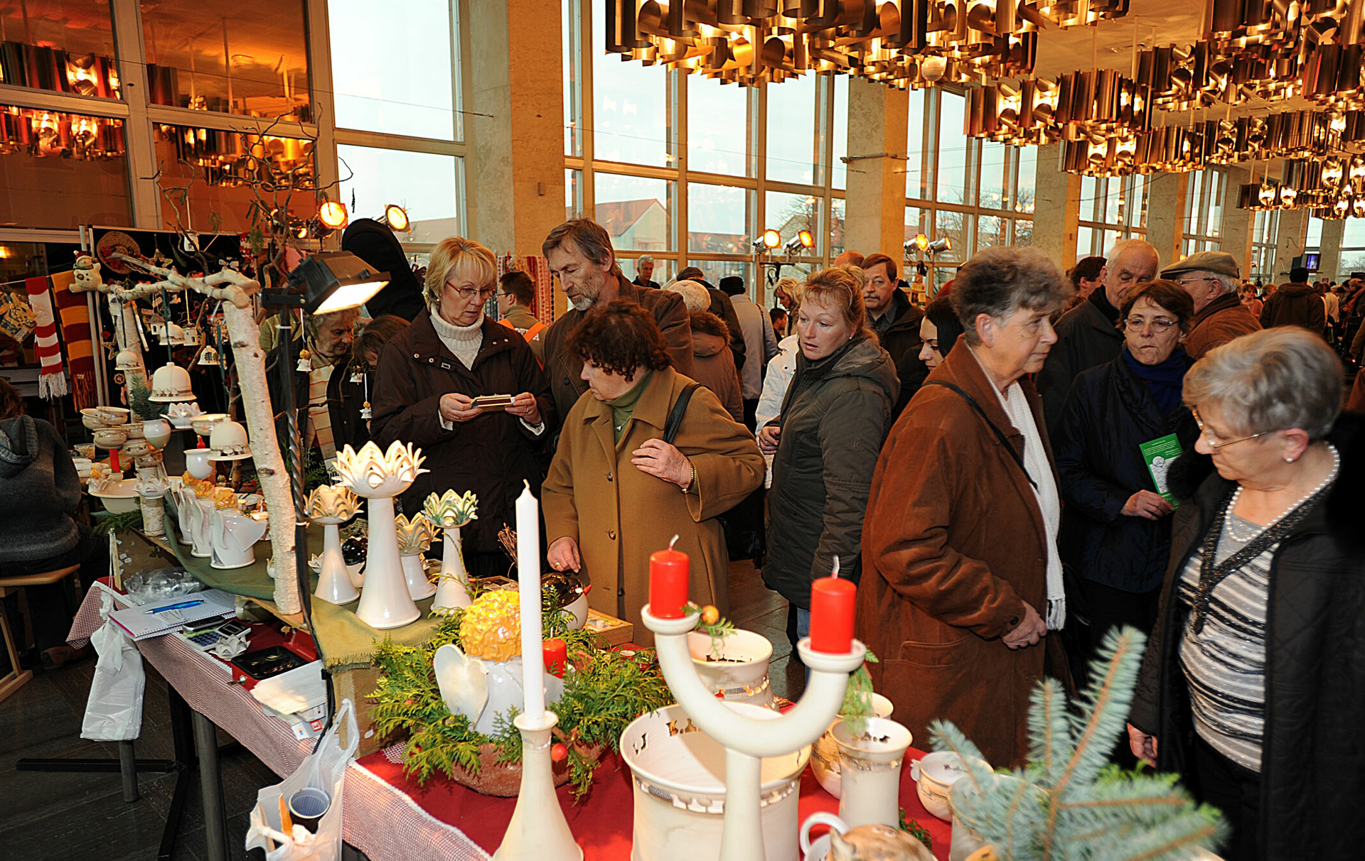 Foto: Besucherinnen und Besucher an weihnachtlichen Ständen Foto: Besucherinnen und Besucher an weihnachtlichen Ständen
