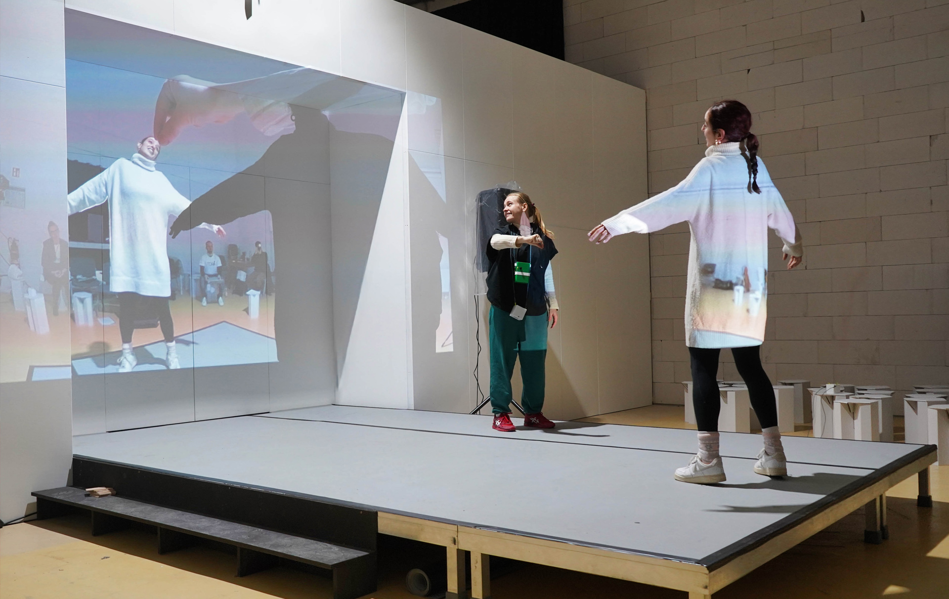 Foto: 2 Schauspielerinnen spielen mit einer digitalen Projektion. Foto: 2 Schauspielerinnen spielen mit einer digitalen Projektion.